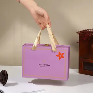Scatola regalo a cassetto viola con manici in nastro dorato, elegante confezione nuziale per dolci.