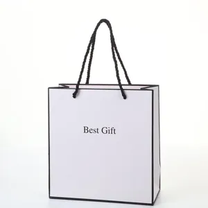 White paper gift bag with black handles and elegant design for shopping and packaging use.
