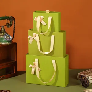 Retro green gift boxes with ribbon handles, elegant rectangular packaging storage boxes.