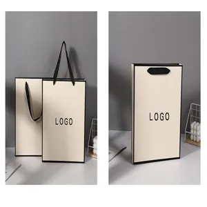 Minimalist beige paper gift bag with black handles and border, ideal for retail and boutique use.