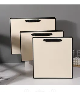 Minimalist beige paper gift bags with black ribbon handles, perfect for boutique packaging.