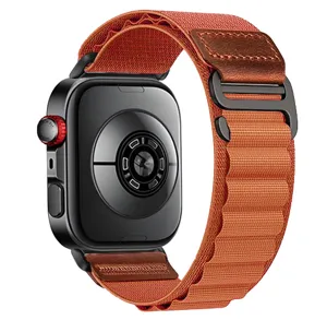 Detail view of the orange nylon loop watch strap with leather patch and secure metal buckle.