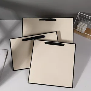 Beige paper gift bags shopping bags with black handles, elegant packaging for retail.