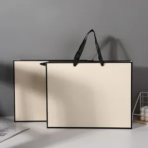 Beige white card paper gift shopping bag with black border and handle for clothing retail.