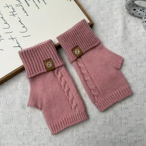 Women pink knit fingerless gloves with cable knit pattern and stylish foldover rib cuff design.