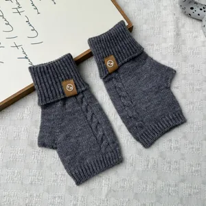 Cozy thick knit fingerless gloves in dark grey with stylish brown leather patch details.
