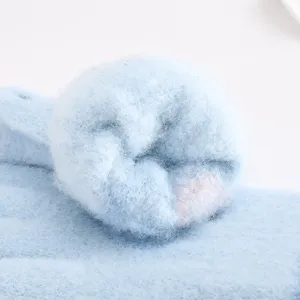 Close-up detail of soft fuzzy winter knitted gloves plush texture cozy warm fabric blue mitten
