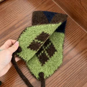 Détail de chauffe-oreilles en tricot argyle coréen, texture en laine pelucheuse et sangle chaude.