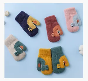 Detailed view of cute toddler winter gloves with dinosaur cartoon design, warm knit material for kids.