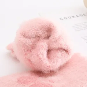 Pink fuzzy winter warm knitted glove texture detail, soft plush cozy material close up