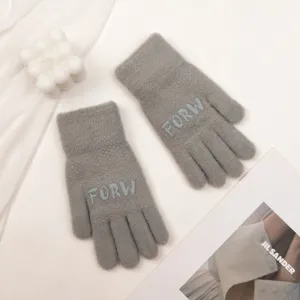 Close-up detail of cozy knit winter gloves in gray with woven letter design, soft texture.