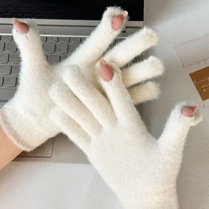 Nahaufnahme weißer Strick-Fingerlos-Handschuhe, weiche flauschige Winter-Handbekleidung.