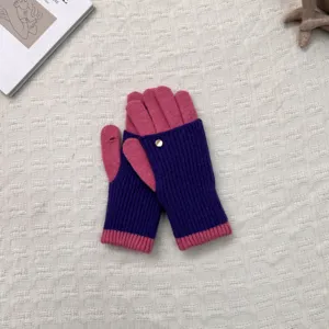 Nahaufnahme Detail der gestrickten, konvertiblen fingerlosen Handschuhe mit Knopfakzent.
