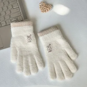 Detailed view of winter warm knitted gloves in cream color with cute bunny embroidery.