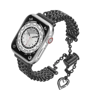 Detalle de correa de reloj de acero, cadena negra con dije de corazón de strass para smartwatch.