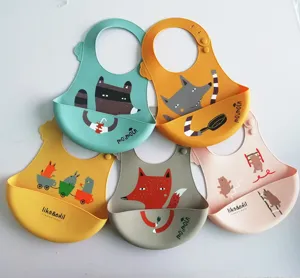 Silicone baby bib detail showing cute animal cartoon prints and waterproof pocket design.