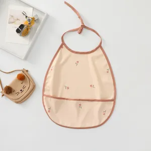 Baby waterproof feeding bib detail shot, cute floral pattern with practical pocket.