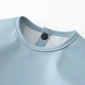 Light blue waterproof baby bib collar detail, soft infant feeding apron close-up view.