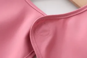 Children waterproof coverall detail shot showing fine stitching and pink waterproof fabric.