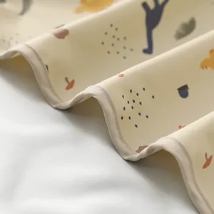 Detailaufnahme der wasserdichten Baby-Urinmatte mit niedlichen Dinos und weichem PU-Material.