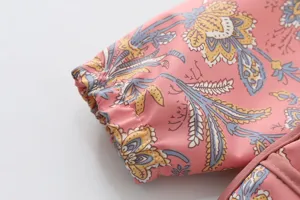 Gros plan sur les détails du poignet de la blouse imperméable pour enfants au motif floral.