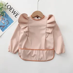 Vue détaillée de la bavoir imperméable pour bébé à manches longues avec jolies ailes d'ange.