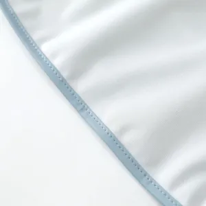 Waterproof baby bib detail showing soft fabric and neat blue edge binding for daily feeding use.