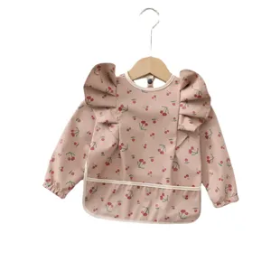 Bavoir imperméable à manches longues pour bébé avec motif de cerises et ailes d'ange mignonnes.
