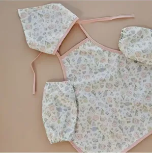 Vista dettagliata del set di grembiuli da pittura floreale per bambini con cuffia e maniche.