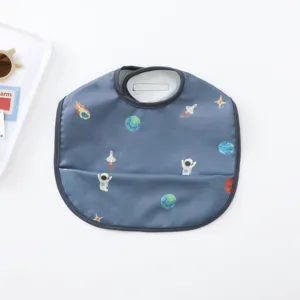 Detailed view of waterproof baby dining bib with cute space astronaut pattern and handy pocket.