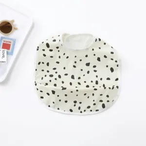 Closeup view of the waterproof baby bib with cute dalmatian spots and handy food catcher pocket.