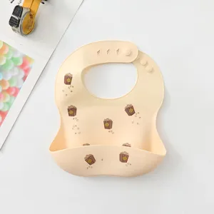 Waterproof silicone baby bib with cute popcorn print, soft pocket, adjustable neck, easy clean.