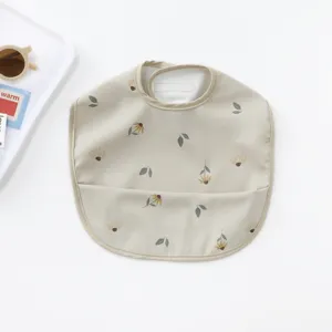 Waterproof baby PU bib with cute floral print and crumb catcher pocket for easy feeding time.