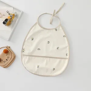 Waterproof baby bib with lemon print, food pocket, and secure tie closure for daily feeding.