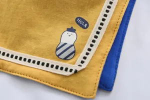 Vue détaillée d'un joli bavoir bébé en coton avec imprimé dessin animé et bordure.