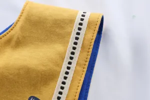 Vue détaillée d'un bavoir pour bébé en coton jaune et bleu avec des coutures propres.