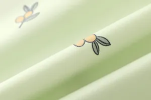 Detailed shot of light green baby changing pad fabric with cute olive branch print, soft texture.