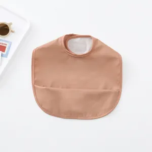 Waterproof baby PU bib with crumb catcher pocket, soft and easy to clean feeding accessory.