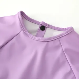 Waterproof baby smock detail view, purple kids feeding bib with snap button closure, soft fabric.