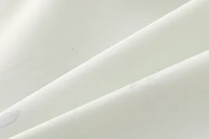 Close-up detail of soft breathable waterproof fabric texture with elegant folds and clean finish.