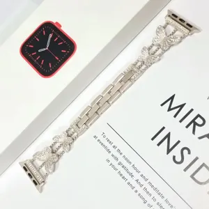 Detalle de correa de reloj de mariposa de metal con diamantes de imitación cristal.