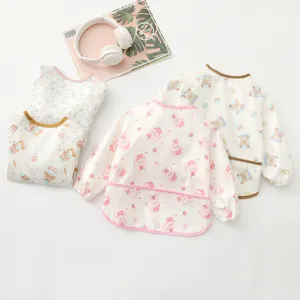 Detailed view of waterproof kids long-sleeve art smock with cute prints and catch-food pocket.
