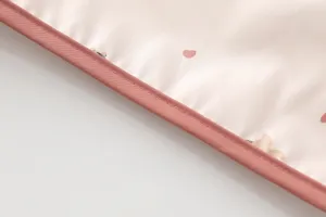 Detailed close-up view of the waterproof baby bib edge with neat pink piping and cute prints.