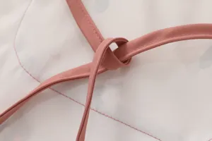 Detailed close-up of the cute pink strap and waterproof fabric on this lovely kids baby bib.