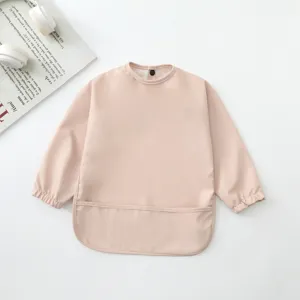 Babero impermeable de manga larga para bebé en rosa claro con bolsillo, ideal para la hora de comer.