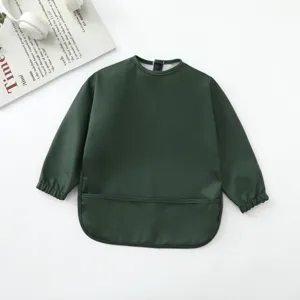 Babero impermeable verde oscuro de manga larga para bebés con bolsillo atrapa migas detalle.
