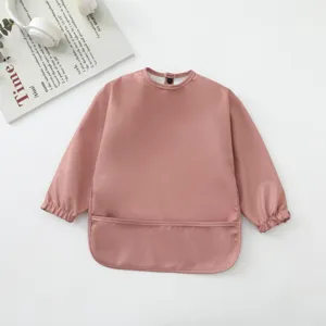 Detalle babero impermeable de bebé manga larga, delantal rosa para niños suave.