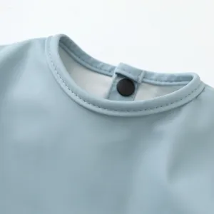 Detalle del cuello del babero de bebé impermeable, tejido ligero con botón a presión muy práctico.