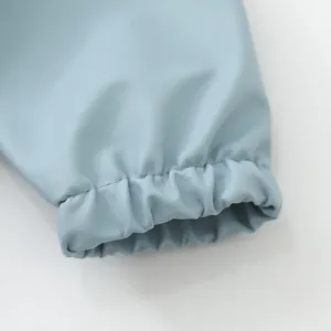 Detalle de manga de babero impermeable para bebé, tela ligera, puño elástico cómodo para uso diario.