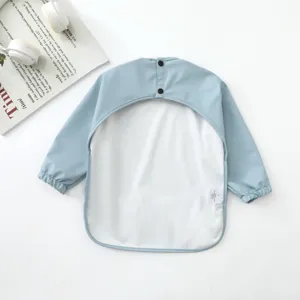 Babero impermeable de manga larga para bebé delantal de alimentación con botones azul claro.